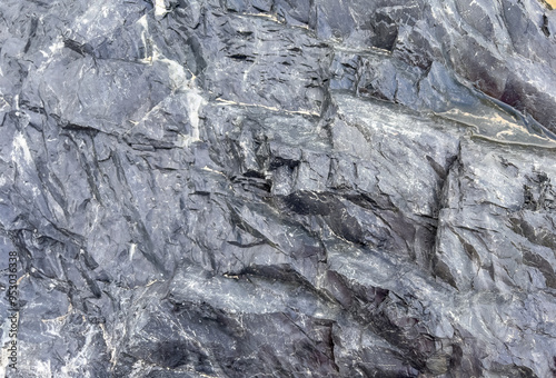 Extremely close up of an interesting hard rock on dark grey shiny  texture pattern of featuring surface pattern highlights background.	