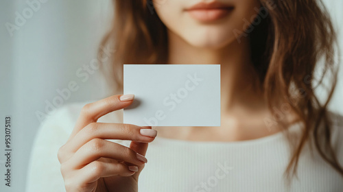 A close-up photograph of a hand holding up an empty white business card photo