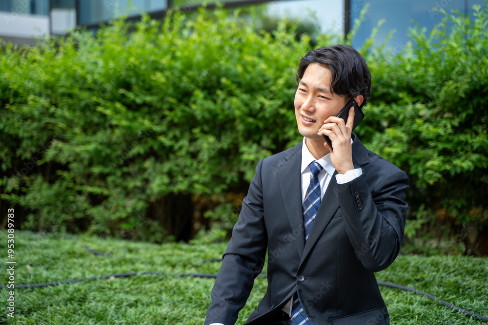 外回り中スマホで連絡するビジネスマン 外回り中スマホで連絡するビジネスマン