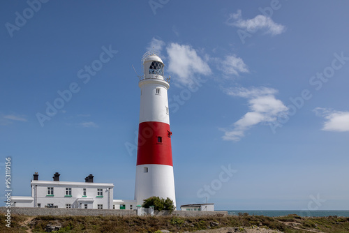 The iconic lighthouse at Portland Bill in Dorset, United Kingdom. Taken with a blue sky and light cloud. there is space for copy text and there are no people