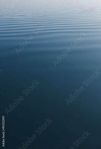 A serene view of calm water with gentle ripples, reflecting a soft blue hue. The surface appears smooth and tranquil, creating a peaceful atmosphere.