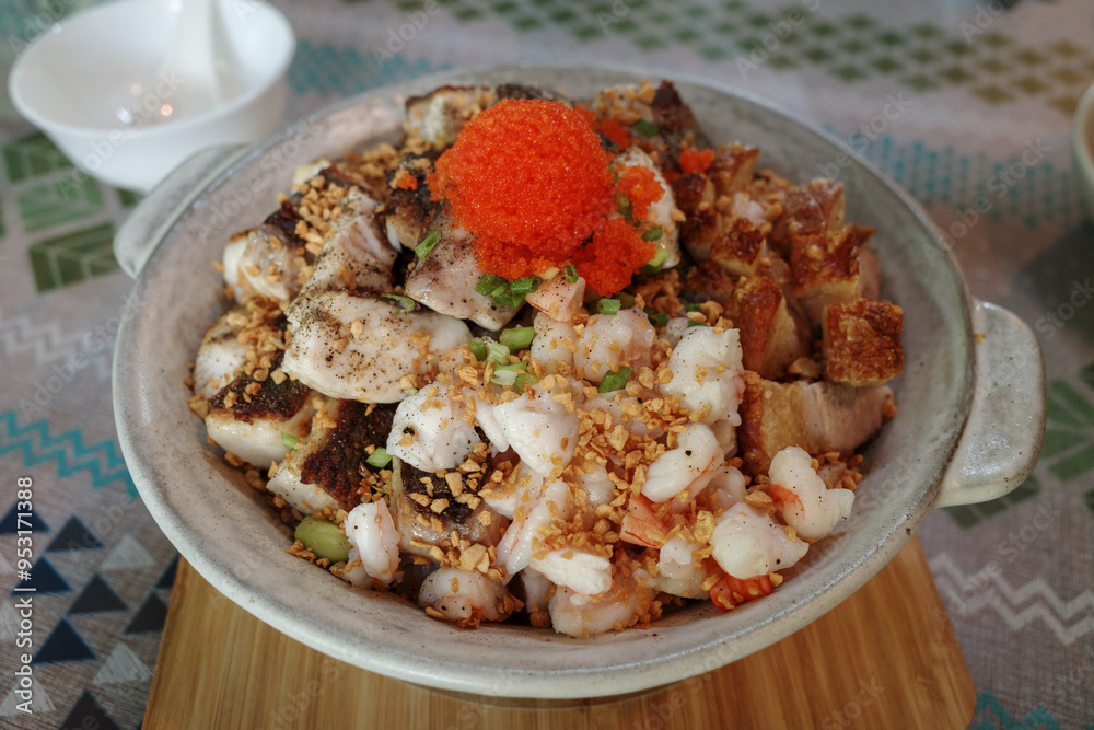 Rice bowl dish featuring a delicious combination of tender seafood, including shrimp, topped with bright orange fish roe and a sprinkling of crispy fried garlic. Rice bowl dish featuring a delicious combination of tender seafood, including shrimp, topped with bright orange fish roe and a sprinkling of crispy fried garlic.