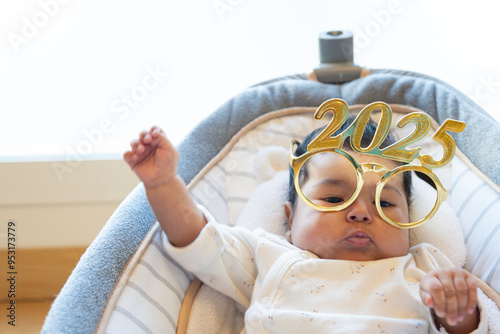 funny portrait of cute dancing baby celebrating with new year 2025 glasses. happy new year 2025 greeting. funny real photo postcard. copy space photo