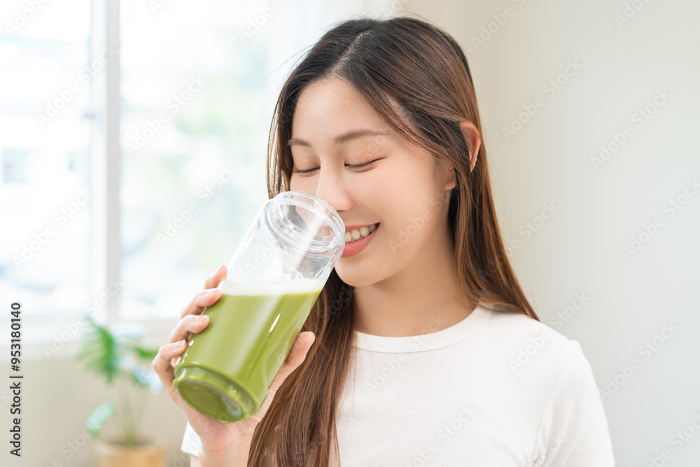 Green detox juice concept, Beautiful smile asian young woman hand holding vegetable smoothie bottle for diet at home. Happy girl drinking healthy meal food for weight loss. Lifestyle, vegan nutrition. Green detox juice concept, Beautiful smile asian young woman hand holding vegetable smoothie bottle for diet at home. Happy girl drinking healthy meal food for weight loss. Lifestyle, vegan nutrition.