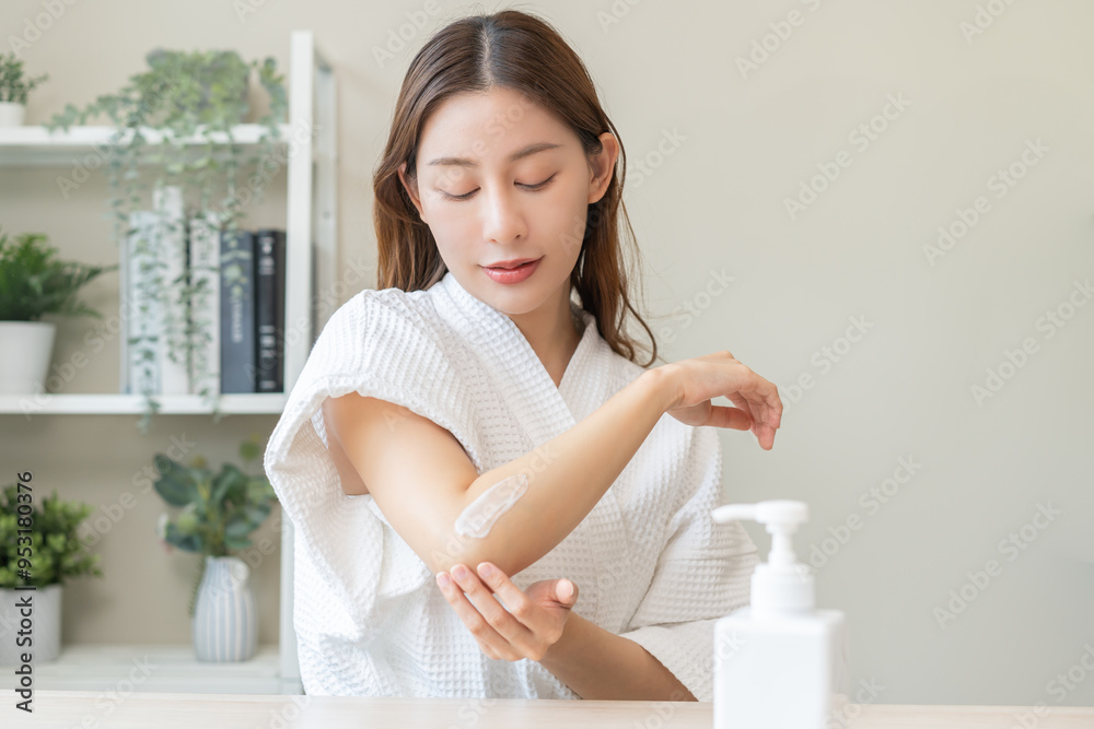 Health care, beauty smile pretty asian young woman in bathrobe, towel after shower bath at home, hand applying, putting moisturizer on her arm. Skin body cream moisturizing lotion, routine in morning. Health care, beauty smile pretty asian young woman in bathrobe, towel after shower bath at home, hand applying, putting moisturizer on her arm. Skin body cream moisturizing lotion, routine in morning.