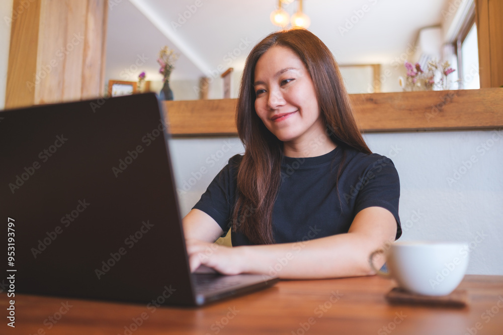 Portrait image of a young woman working on laptop computer in cafe Portrait image of a young woman working on laptop computer in cafe