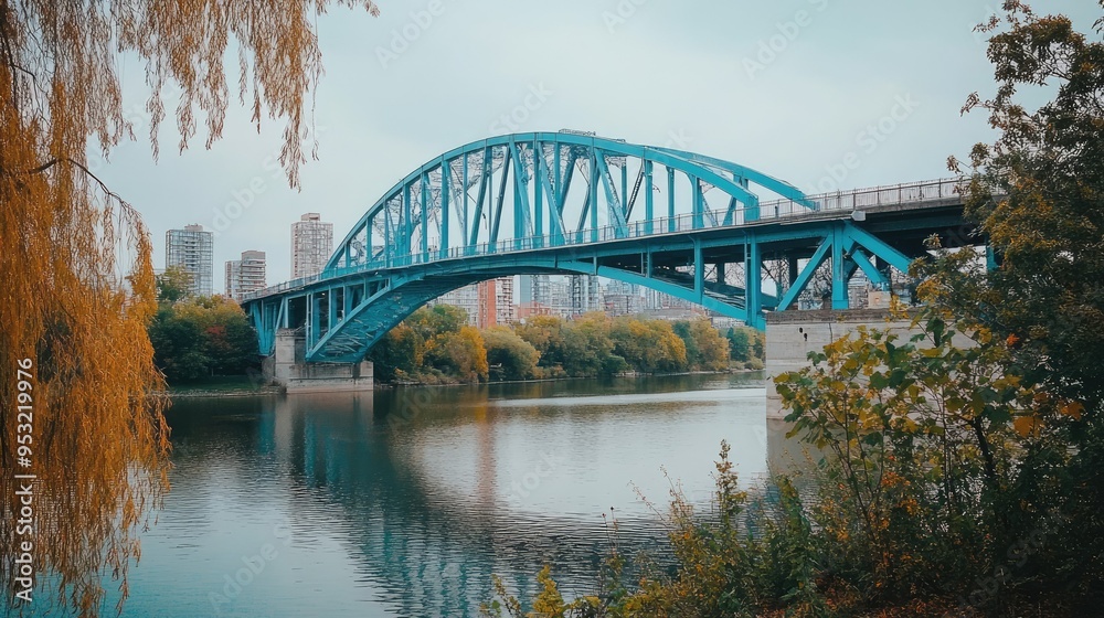 Obraz premium A wide shot of a blue bridge spanning across a river, connecting two urban areas
