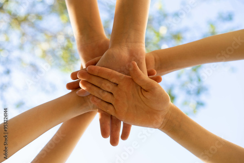 children holding hands, standing on the green grass, the concept of friendship and a group of young people working in a team, a circle of hands
