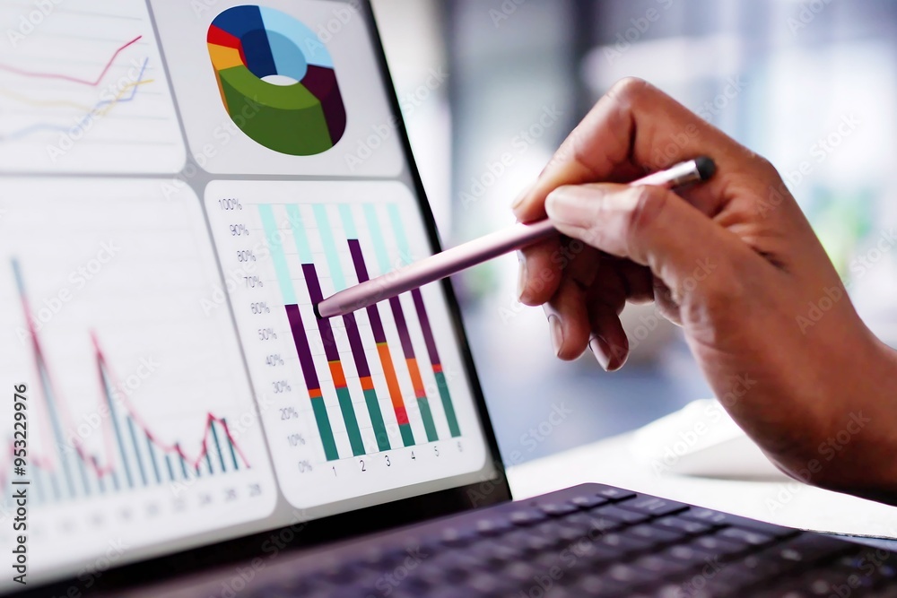 © Andrey Popov - African American woman analyzing financial data on laptop screen