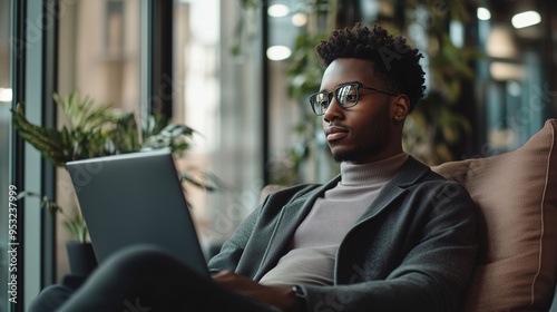 Young Business Professional Working on Laptop in Modern Lounge photo