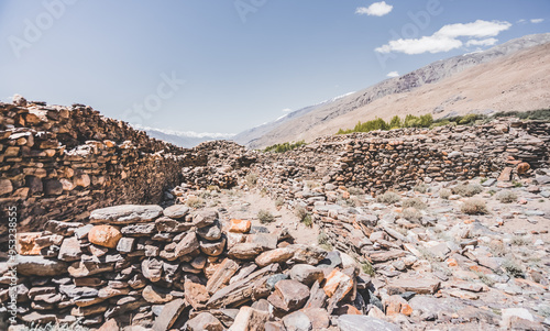 Remains of the ancient fortress of Yamchun in the Tien Shan mountains in Tajikistan in the Pamirs, ruins of a fortress fort made of stone on the background of mountains photo