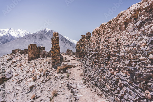 Remains of the ancient fortress of Yamchun in the Tien Shan mountains in Tajikistan in the Pamirs, ruins of a fortress fort made of stone on the background of mountains photo