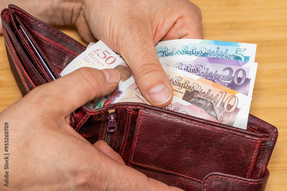 Hand takes out money from the wallet, British Pound banknotes, concept, rising prices, value of English currency