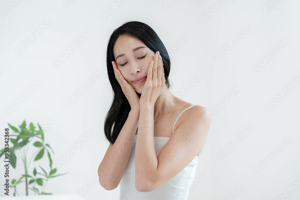 頬に手を当て満足感を感じる女性