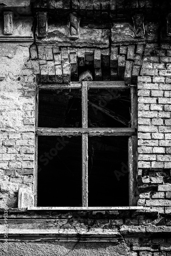 A VERY OLD HOUSE - A window in a neglected and dilapidated brick building 