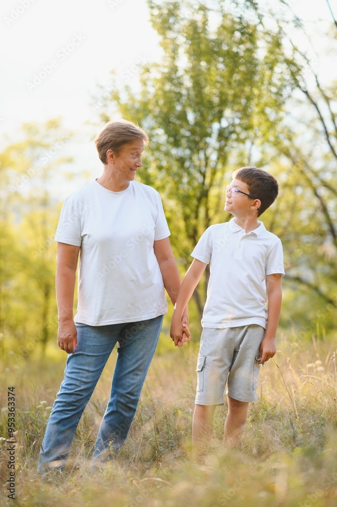 Grandmother and her little grandchild together in sunny summer park