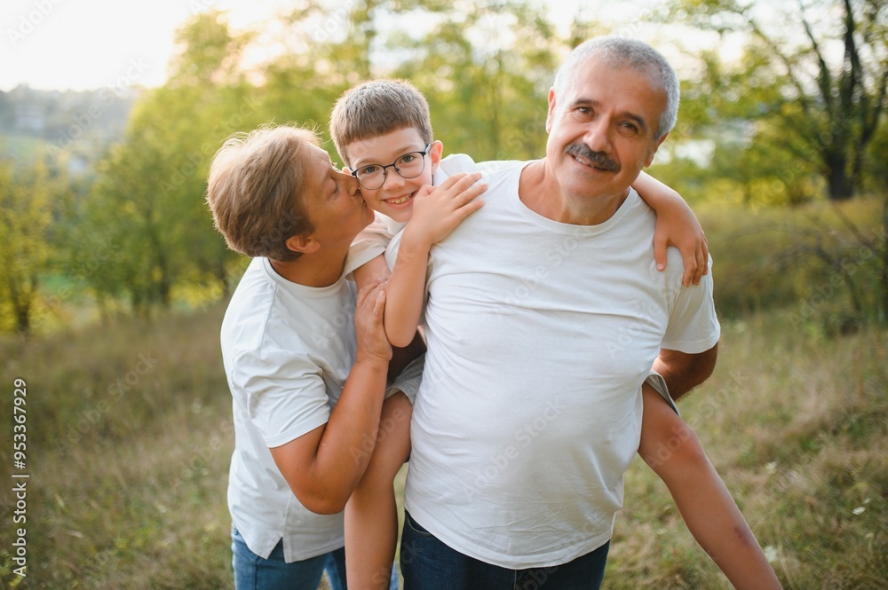 Grandparents walking with they grandson in summer sunset Grandparents walking with they grandson in summer sunset