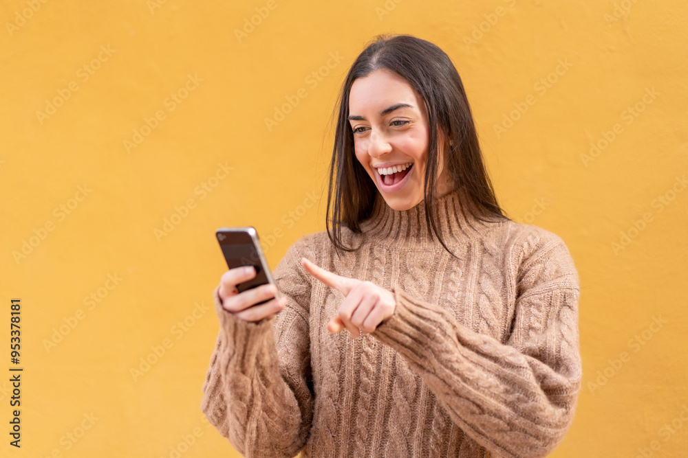 Young brunette woman at outdoors sending a message or email with the mobile Young brunette woman at outdoors sending a message or email with the mobile