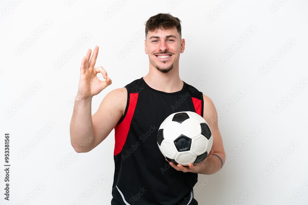 Young caucasian handsome man isolated on white background with soccer ball and making OK sign Young caucasian handsome man isolated on white background with soccer ball and making OK sign