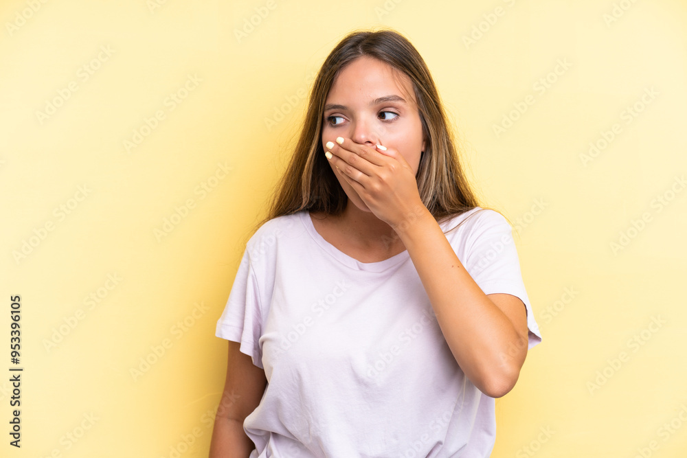 Young caucasian woman isolated on yellow background doing surprise gesture while looking to the side Young caucasian woman isolated on yellow background doing surprise gesture while looking to the side