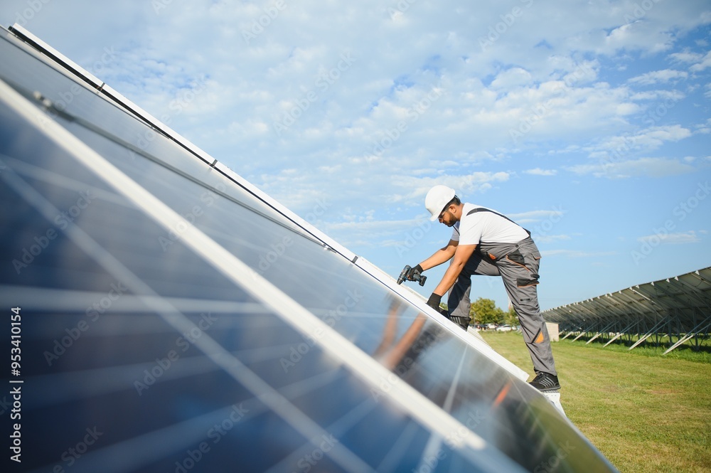 Naklejka premium Indian worker installing solar panels. Concept of alternative, renewable energy