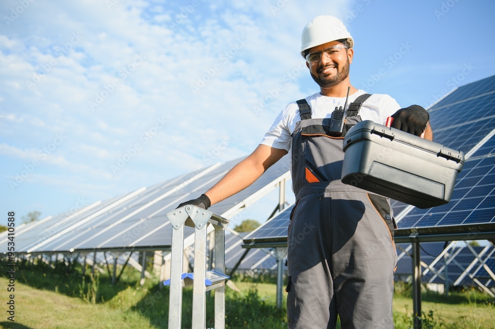 Portrait of handsome Indian worker near solar panels Portrait of handsome Indian worker near solar panels
