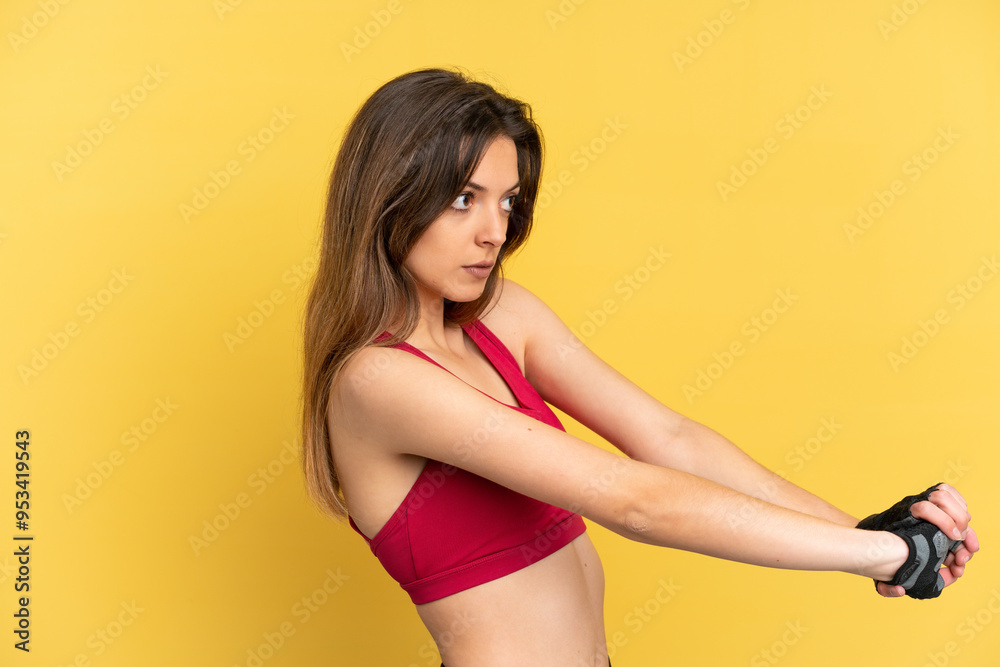 Obraz premium Young caucasian woman isolated on blue background stretching