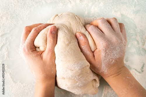 hands in flour crumple the dough for pizza or pies, the process of cooking bakery products