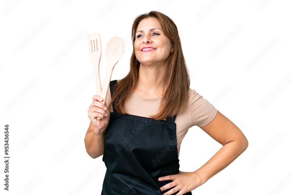 Middle age caucasian woman holding a rolling pin over isolated background posing with arms at hip and smiling Middle age caucasian woman holding a rolling pin over isolated background posing with arms at hip and smiling