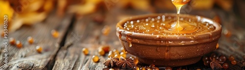 Golden honey drizzles from a wooden spoon into a rustic bowl, surrounded by delicate autumn leaves and warm wooden textures. photo