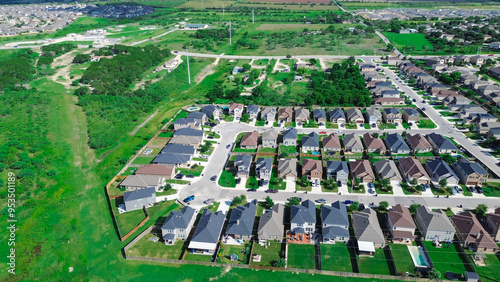 Suburban sprawl with vacant land for growth in suburbs San Antonio, Texas, row of two-story new development single family houses with large backyard, undeveloped land near a city, aerial view photo