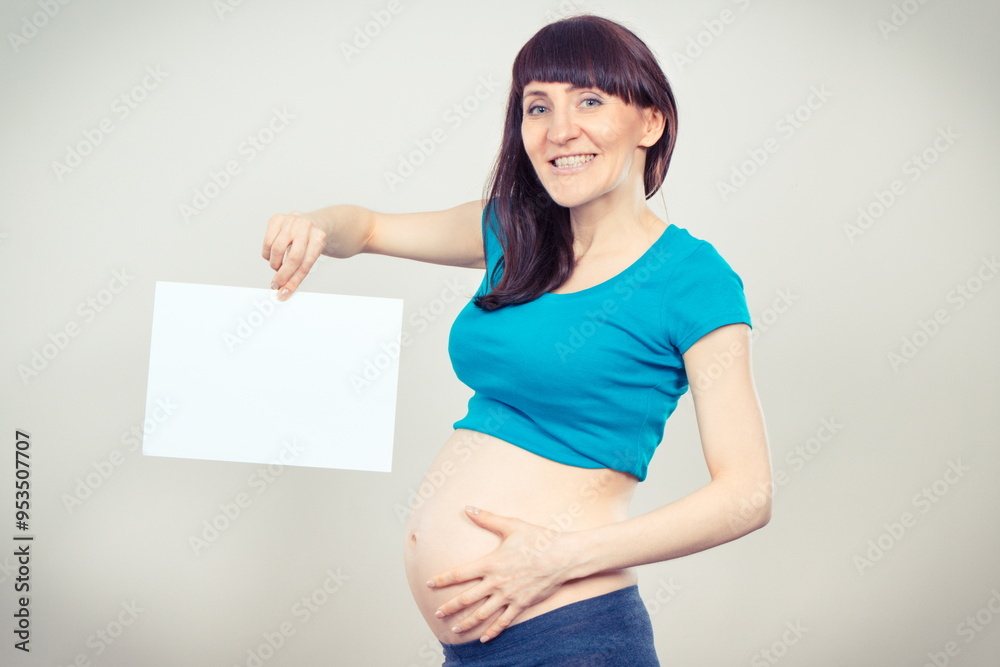 Happy woman in pregnant holding empty card for text. Expecting for newborn. Extending family. Motherhood Happy woman in pregnant holding empty card for text. Expecting for newborn. Extending family. Motherhood