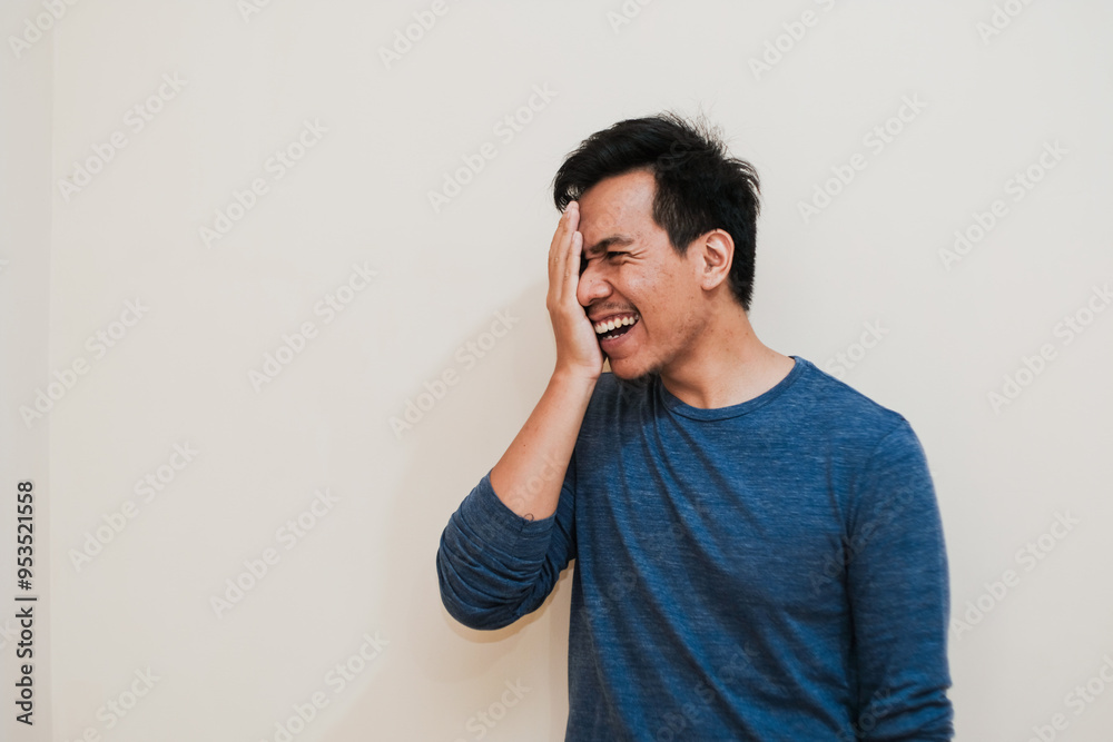 Portrait of happy Adult Southeast Asian man covers half face with palm cream background, positive emotion, copy space. Portrait of happy Adult Southeast Asian man covers half face with palm cream background, positive emotion, copy space.