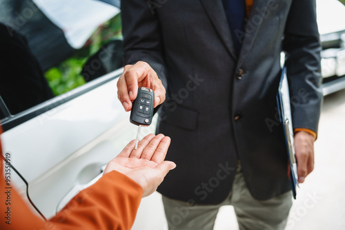 Car seller agent signs a car insurance agreement with salesman. The document outlines vehicle policy, premium, rental terms, with contract paper finalized using car insurance claim mobile phone.