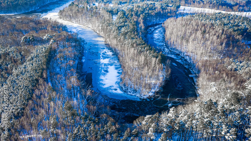 Frozen river and snowy fore...