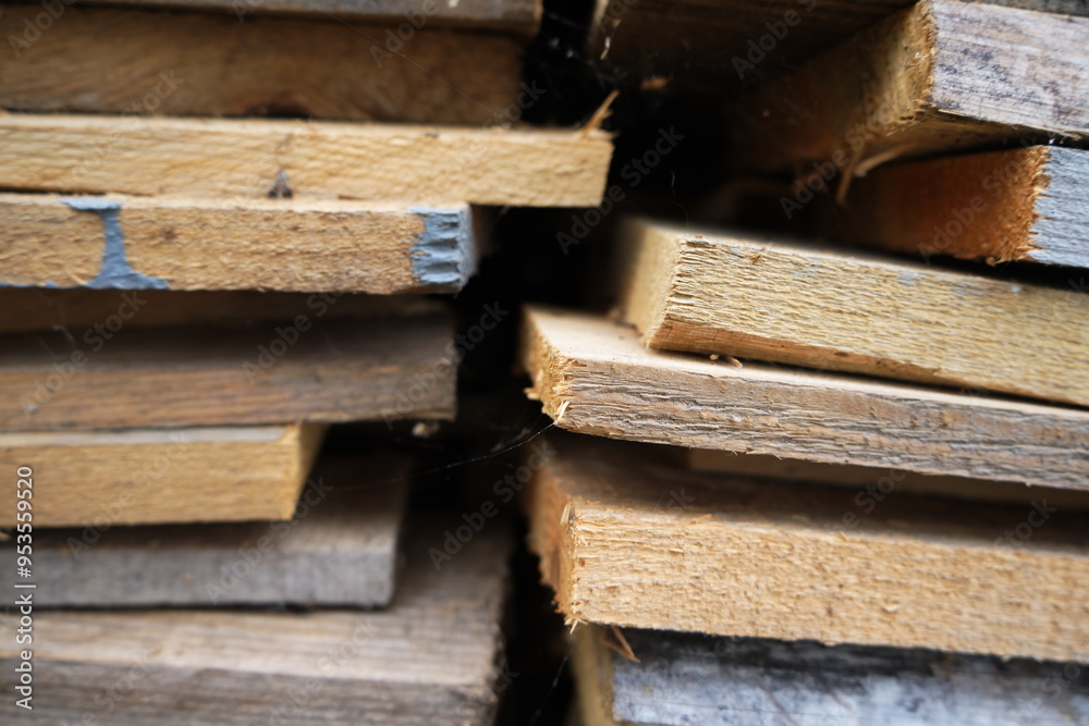 A close-up of stacked wooden planks with visible textures and grain, some with chipped edges and a hint of blue paint, creating an abstract pattern. Ideal for carpentry, construction, and DIY projects A close-up of stacked wooden planks with visible textures and grain, some with chipped edges and a hint of blue paint, creating an abstract pattern. Ideal for carpentry, construction, and DIY projects