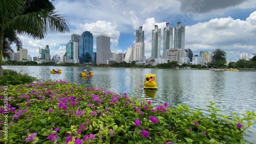 People ride a paddle boat in lake of Benjakitti Park, also known as Benchakitti, in Bangkok, Thailand. The park is located in the main business district of Thailand's capital. photo