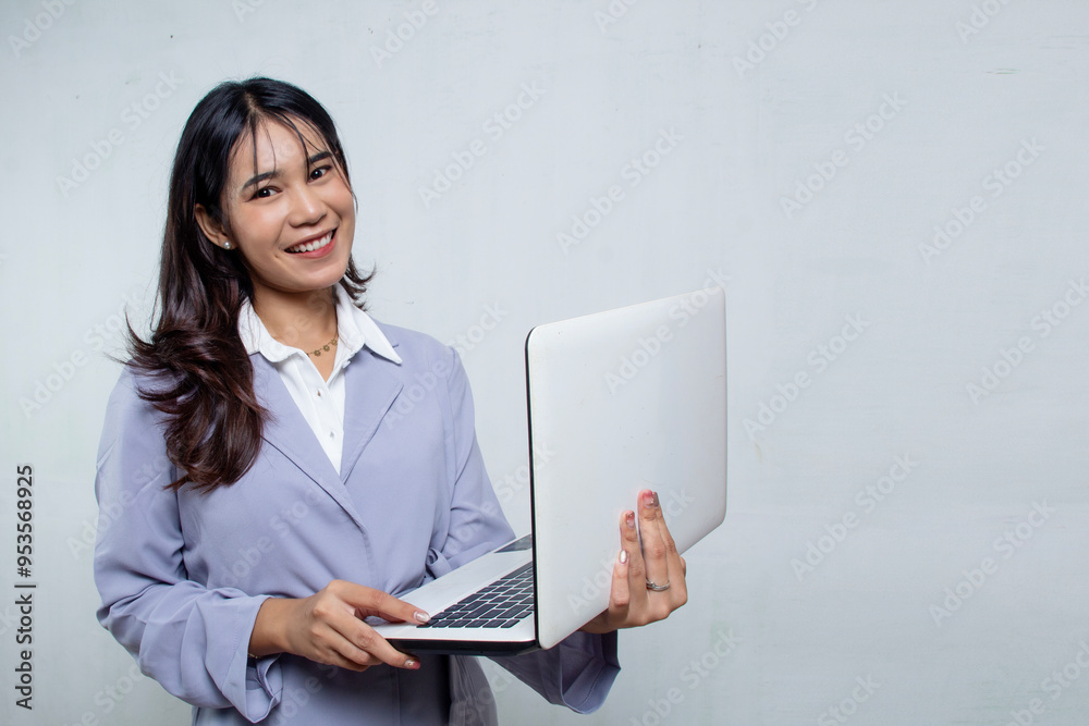 Beautiful Asian business woman standing and using her laptop in dark blue shirt on white background, office woman advertisement, negative space Beautiful Asian business woman standing and using her laptop in dark blue shirt on white background, office woman advertisement, negative space