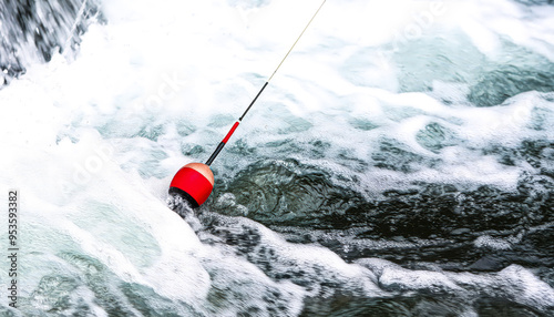 Red bobber floats in a rushing river