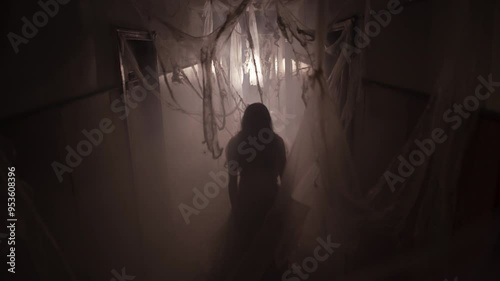 Ghost in abandoned house in the middle of cobweb. Horror scene of scary of young woman. Halloween photo