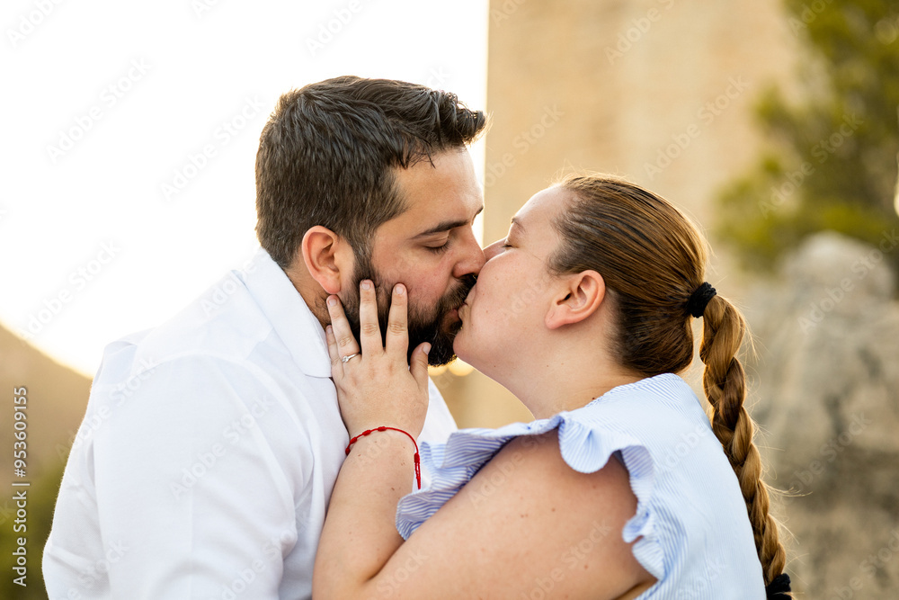 Fototapeta premium A fat couple take some photos for a pre-wedding session in the surroundings of Jaén.The couple are kissing romantically.Concept of love between stuffed people.
