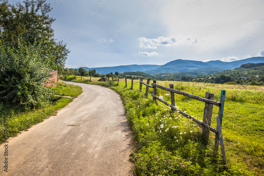Explore a scenic country pathway surrounded by lush greenery and a beautiful landscape Explore a scenic country pathway surrounded by lush greenery and a beautiful landscape