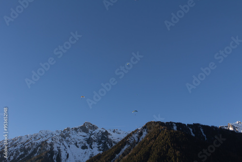 Paraplan and deltaplan in alps over a ski resort
