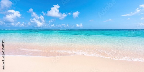 A clear, sandy beach with a panoramic view of the cloudy, sunny sky, a picturesque natural setting, and the stunning sea on a sunny day