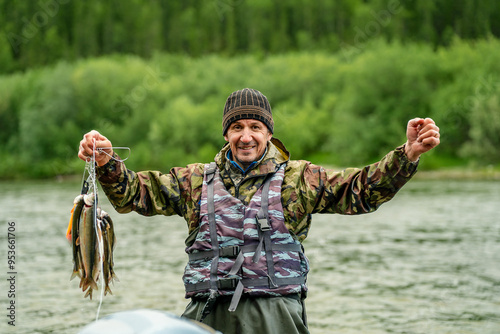 Male fisherman smiling and holding caught fish