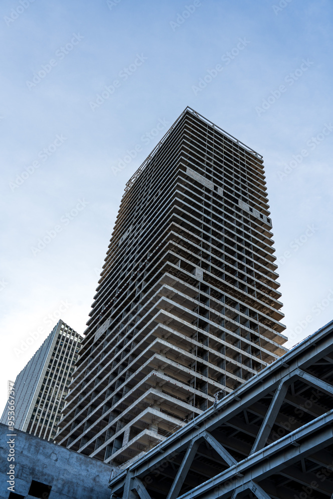 Modern Architectural Construction of a High-Rise Building Against a Clear Sky Modern Architectural Construction of a High-Rise Building Against a Clear Sky