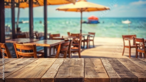 Empty wooden tabletop with blurred beachfront cafe background