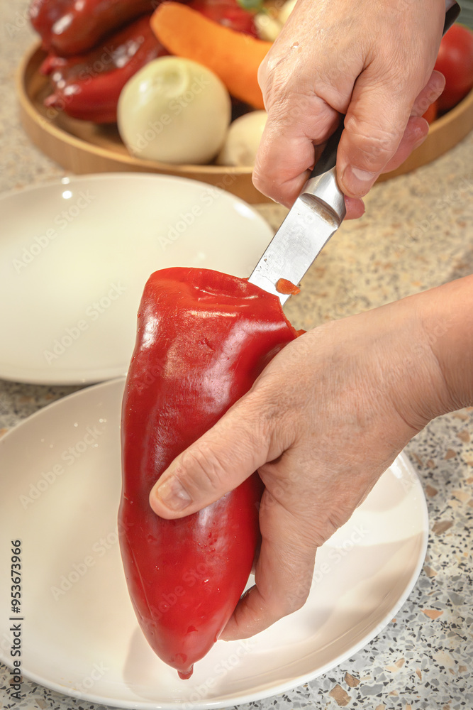 © alexey_arz - Cook uses a knife to clean out the seeds from a red bell pepper for subsequent stuffing. Close-up