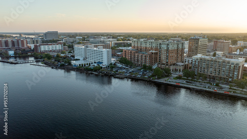 Aerial view of historic downtown Wilmington, NC, with buildings reflecting the sunrise over the Cape Fear River.