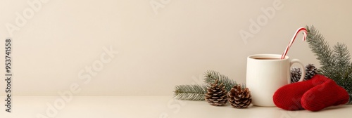 A cozy Christmas flat lay featuring a mug of hot chocolate topped with a candy cane, pine branches, pine cones, and red mittens. The image evokes feelings of warmth, comfort, and holiday cheer. photo